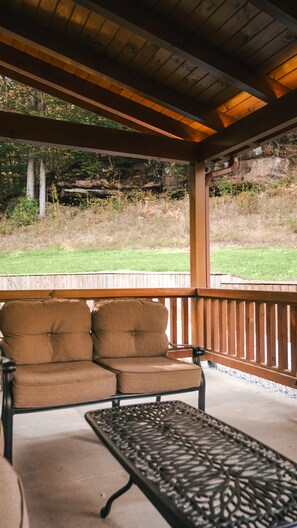 Une véranda avec un banc et une table.