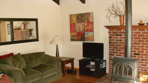 A living room with a green sofa, a wooden coffee table, a television, and a fireplace. - Comfortable, Spacious, Pet-Friendly Home
Located close to all the best of Tahoe (South Lake Tahoe)