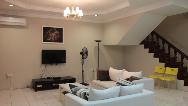 Ein Wohnzimmer mit Sofa, Fernseher und einer Treppe.