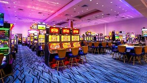 Un casino con numerosas máquinas de juego y sillas dispuestas en filas.