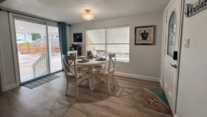 Un espace repas comprenant une table ronde, des chaises et un luminaire suspendu au plafond.