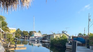Un port de plaisance avec des bateaux amarrés, un ciel dégagé et des bâtiments en arrière-plan.