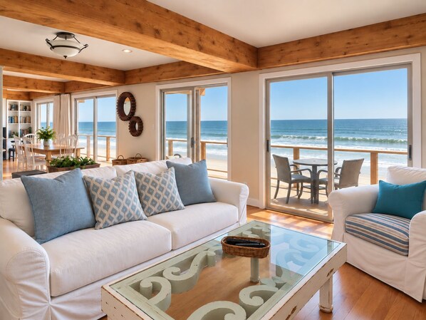 Ein Hotel direkt am Strand mit Wohnzimmer, Essbereich und Meerblick.