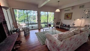 A spacious living room with a large sofa, a dining table, and a fireplace.