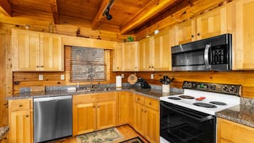 A kitchen with wooden cabinets, a stainless steel dishwasher, a microwave, and a stove.