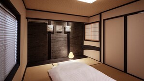 A traditional Japanese-style room with tatami flooring, a low bed, a shoji screen, and a ceiling light fixture. - Rinn Tenjincho (Kyoto)