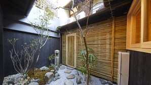 A traditional Japanese garden with a stone pathway, rocks, and a bamboo fence. - Rinn Tenjincho (Kyoto)