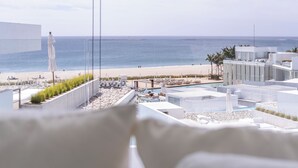 Een modern hotel met een zwembad op het dak met uitzicht op een strand.