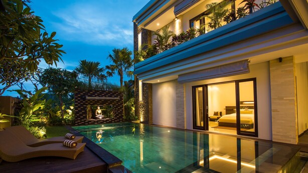 Ein modernes Haus mit Swimmingpool, Meditationsbereich und einem gut beleuchteten Schlafzimmer.