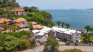 A coastal hotel with multiple buildings, a swimming pool, and a parking area. - Newly Remodeled Beachfront Condo, Ground-Floor Terrace & Direct Access to Playa Flamingo (Santa Cruz, Guanacaste, Playa Flamingo)