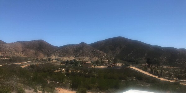 A mountainous landscape with a small settlement and sparse vegetation.