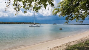 A calm lake with a sailboat anchored near the shore, surrounded by trees and a clear sky. - Aarons Villa - Waterfront Perfectly located on Gympie Terrace (NOOSAVILLE)