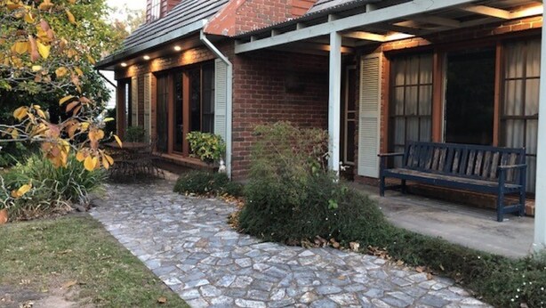 A brick house with a stone pathway leading to a porch with a bench. - Mansfield House - Country Holiday Accommodation, Sleeps 10, up to 15 (Mansfield)