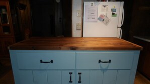 Cozinha com bancada de madeira e armários azul-claros.