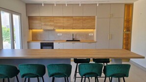 Een moderne keuken met een groot eiland, barstoelen en inbouwmeubels.