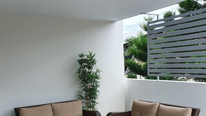 A patio area with two brown wicker sofas with beige cushions, a rectangular coffee table, and a patterned rug. - Accommodation South Bank Brisbane 25meters from  Exhibition & Convention Centre  (South Brisbane)