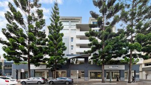A modern building with multiple floors, featuring balconies and a covered entrance. - Accommodation South Bank Brisbane 25meters from  Exhibition & Convention Centre  (South Brisbane)