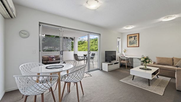 A modern living room with a dining area, a sofa, a TV, and a painting on the wall. - Accommodation South Bank Brisbane 25meters from  Exhibition & Convention Centre  (South Brisbane)