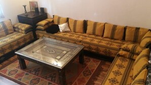 A living room with a sofa set, a coffee table, and a patterned rug. - A Cozy Flat In A Quite Neighborhood (Fès)