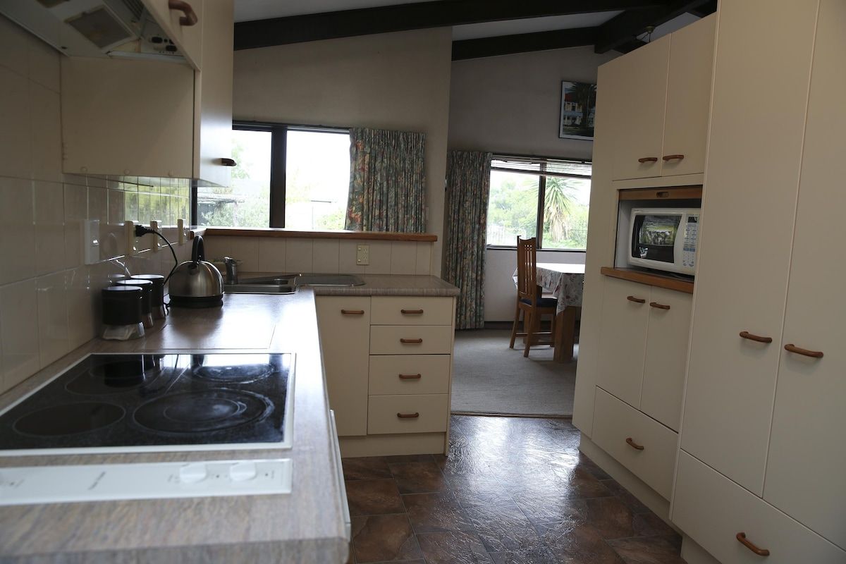 A kitchen with a stove, microwave, and cabinets.