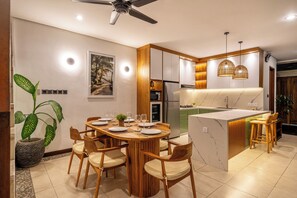 A modern kitchen with a central island, wooden cabinetry, and pendant lighting. - 2 BR Villa Mienna, 2 Mins Walk to Restaurants (Badung)