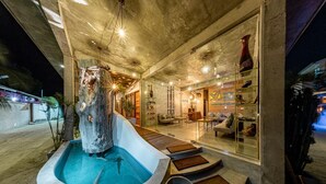 A modern spa area with a large stone water feature, seating areas, and a reception desk. - Club Gabbiano Rasdhoo (Rasdhoo)