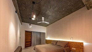 A bedroom with a bed, a bench, a ceiling fan, and a wall-mounted light. - Club Gabbiano Rasdhoo (Rasdhoo)