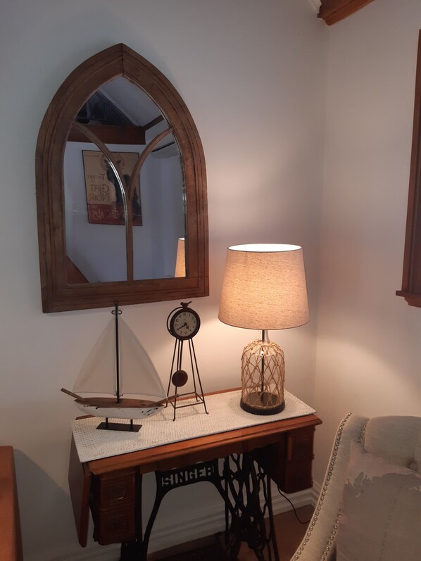 Un bureau avec une lampe, une horloge et un miroir.