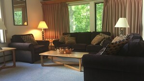 A cozy living room with two sofas, a coffee table, and two lamps.
