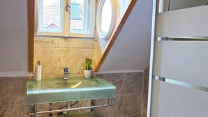A bathroom with a glass sink, a window, and a shower area. - Amazing house with beautiful garden, 5 bedrooms, terrace, in the City Centre (Sibiu)