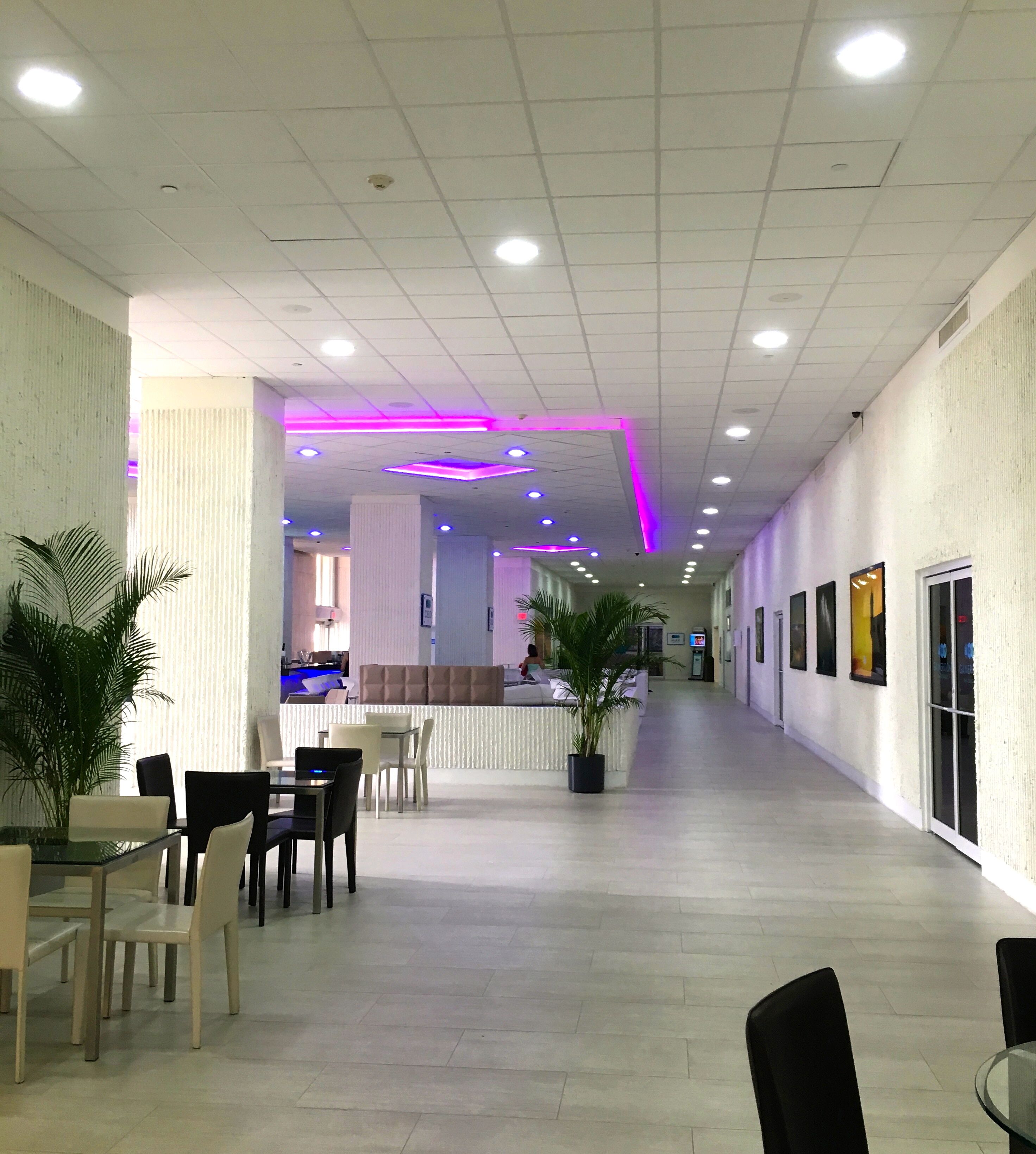 A hotel corridor with a reception area, seating, and a long hallway.
