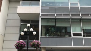 A modern building with a two-story structure, large windows, and a visible garage entrance. - Bright and airy 2bed/2bath condo in the heart of downtown Victoria (Victoria)