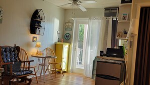 A room with a ceiling fan, a dining table with chairs, a refrigerator, and a bed. - Beachy Condo! Cozy studio 3 minutes to Wells Beach (Wells)