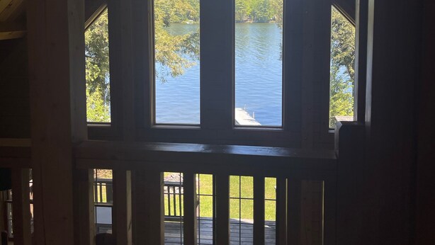 Una cabaña de madera con un amplio ventanal que da a un lago.