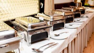 A buffet setup with multiple serving stations, each with a metal container and a spoon.