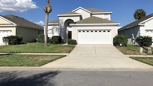 A residential house with a garage, a driveway, and a well-maintained lawn.