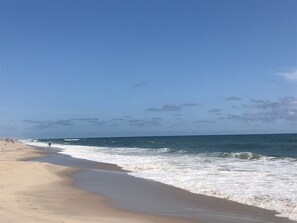 Ein Strand mit sandigem Ufer und Wellen.