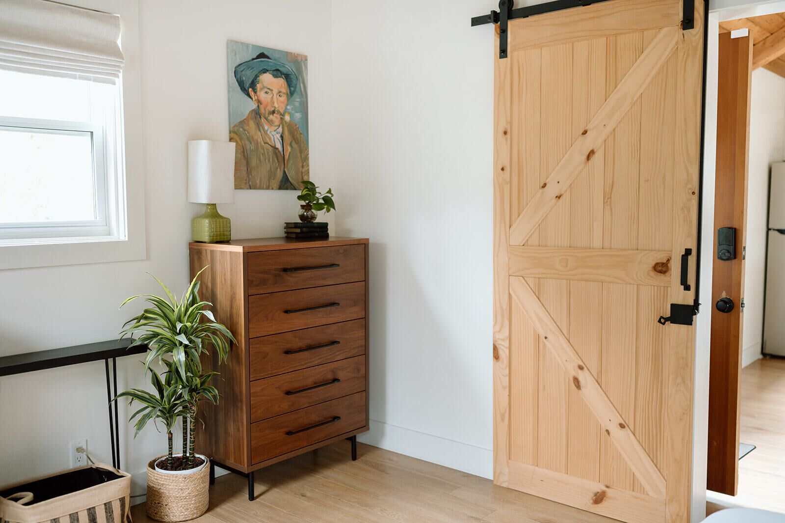 Een kamer met een houten kast, een potplant en een schuifdeur van hout.
