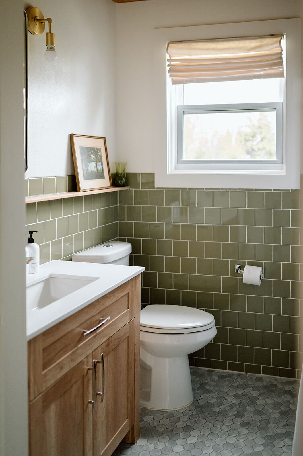Een badkamer met toilet, wastafel en badkamermeubel.
