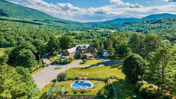 A large, multi-story building surrounded by lush greenery and a swimming pool. - Family Reunion Gem!  Pool, Tennis, Deck, Fireplace, Views, Privacy - Dogs loved (Manchester)