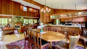 A spacious living room with a fireplace, wooden paneling, and a large dining table with chairs. - Family Reunion Gem!  Pool, Tennis, Deck, Fireplace, Views, Privacy - Dogs loved (Manchester)