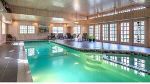 An indoor swimming pool with wooden walls and ceiling, surrounded by windows and chairs. - Family Reunion Gem!  Pool, Tennis, Deck, Fireplace, Views, Privacy - Dogs loved (Manchester)