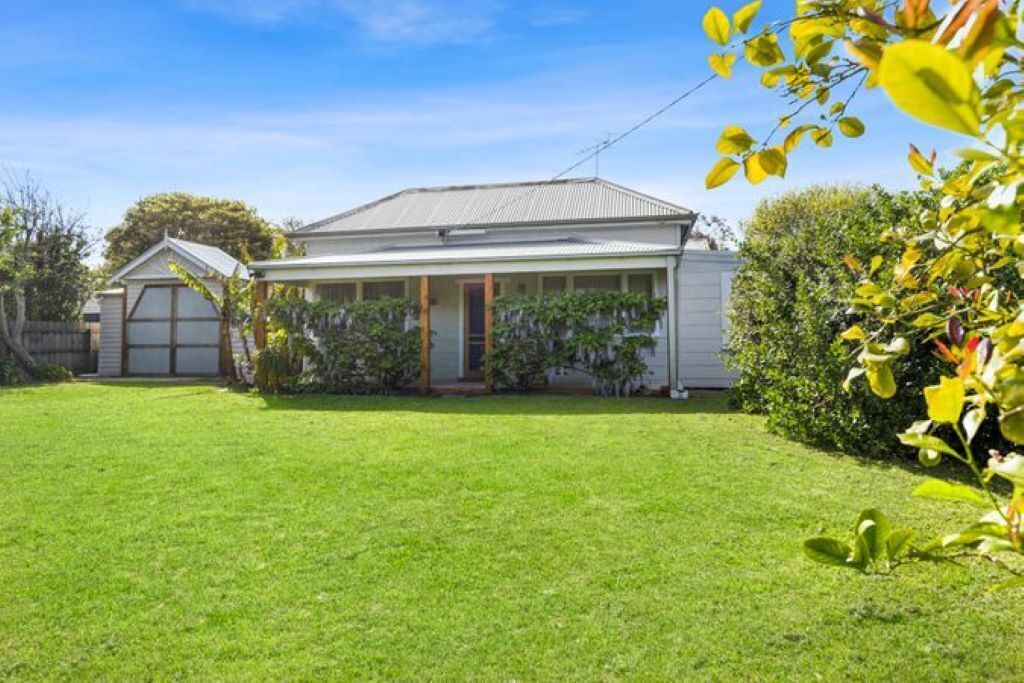 A single-story house with a front porch, a garage, and a well-maintained lawn.