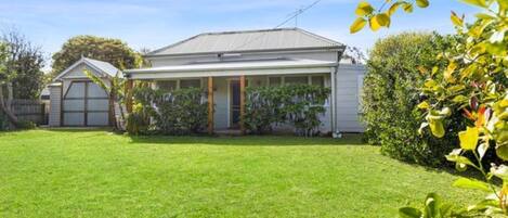 A single-story house with a front porch, a garage, and a well-maintained lawn.