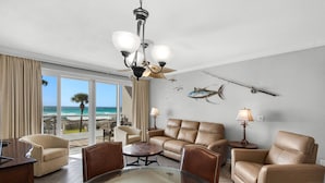 A hotel room with a balcony, leather furniture, a ceiling fan, and wall-mounted fish decorations. - 104 Sterling Sands Oceanfront Paradise Found! Steps to the Beach! (Destin)