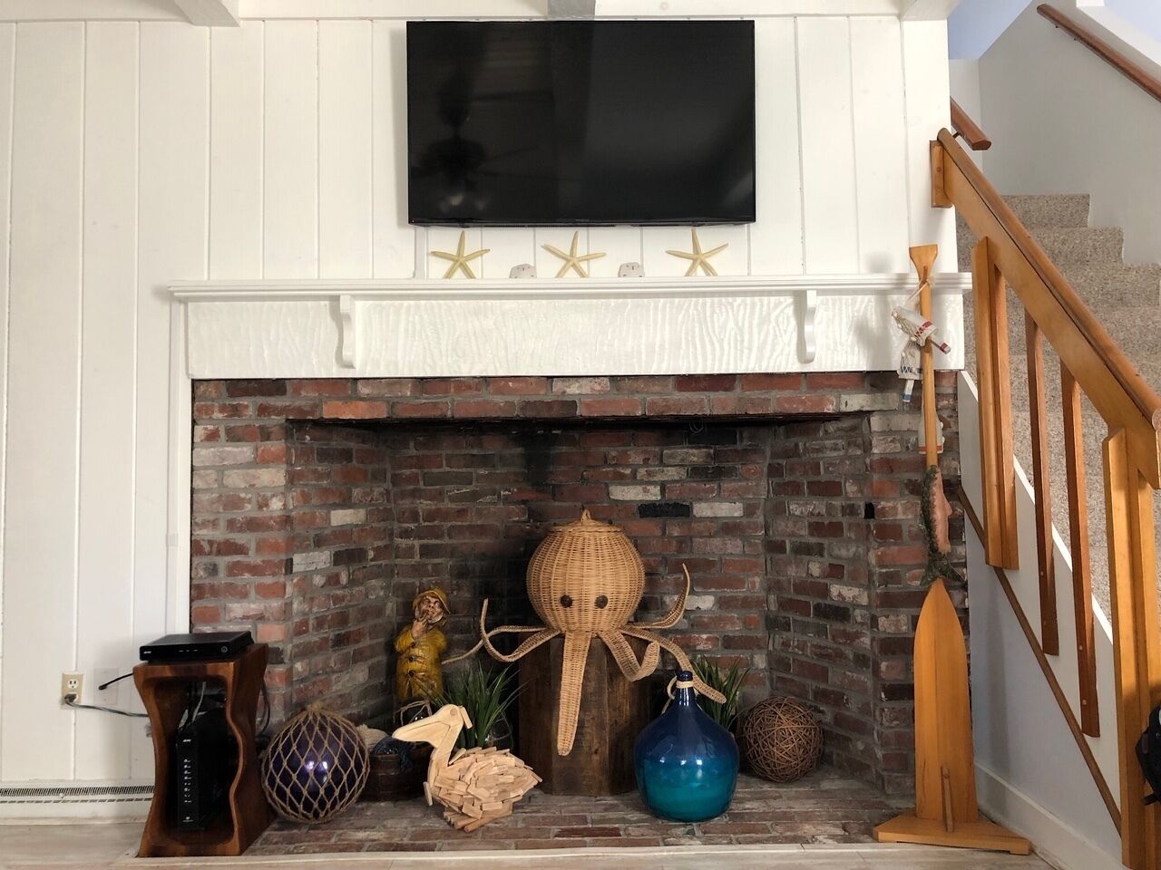 A fireplace with a TV above it, surrounded by various decorative items.