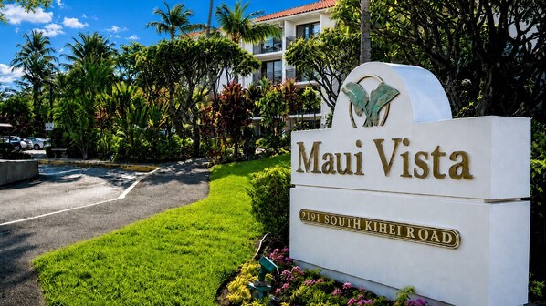 A sign for 'Maui Vista' with a clear view of the address '2191 South Kihei Road' and a well-maintained lawn with tropical plants.
