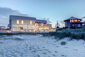 A beachfront property with a large house, a smaller structure, and a beach with footprints. - OCEAN VIEW studio apt BEST LOCATION (New Smyrna Beach)