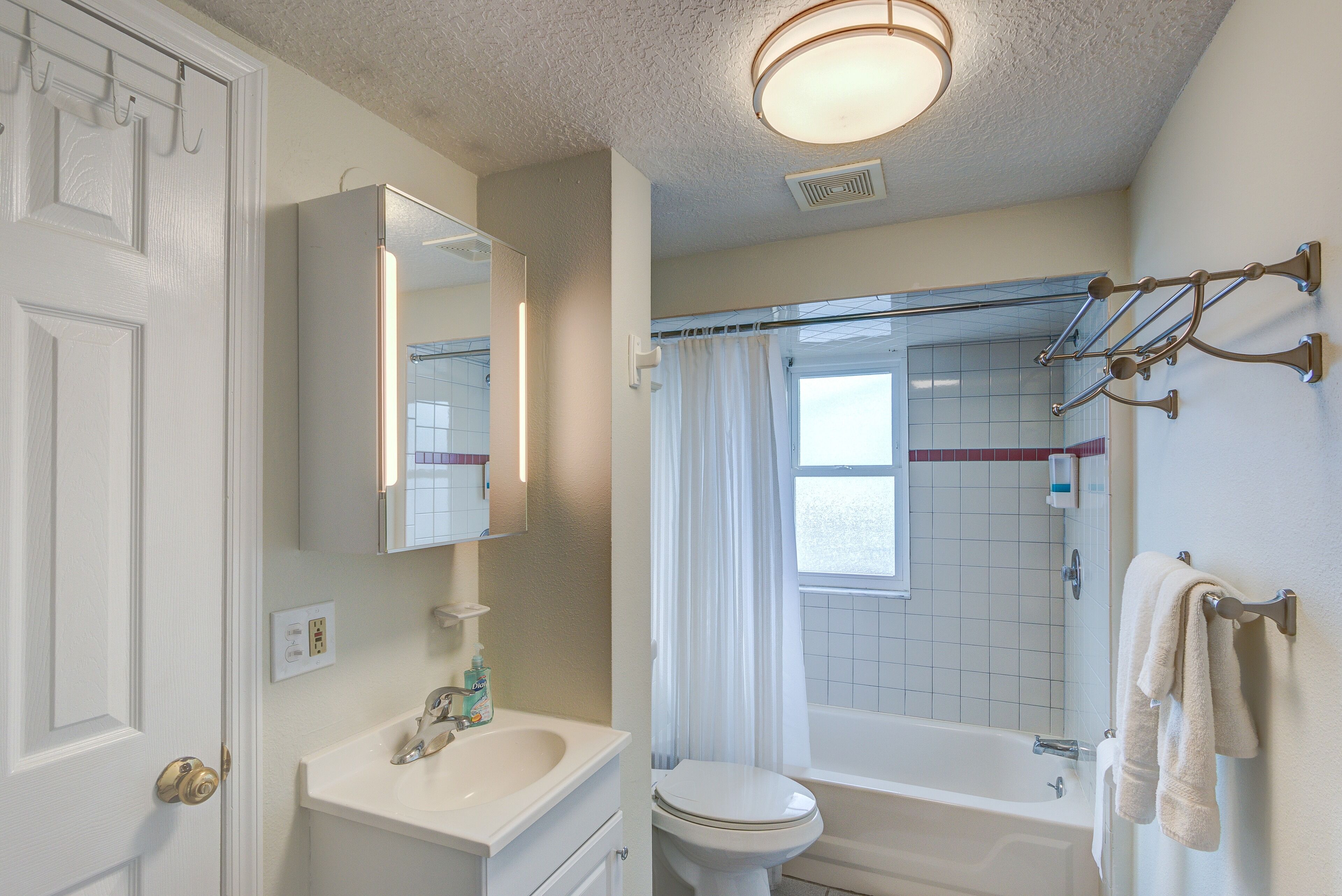 Une salle de bain avec des toilettes, un lavabo et une baignoire.