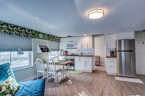 A compact kitchen with white cabinets, a stainless steel refrigerator, and a microwave. - OCEAN VIEW studio apt BEST LOCATION (New Smyrna Beach)